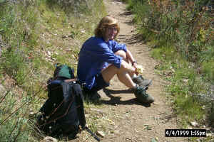 A tired hiker rests on the trail