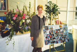 Jane with flowers and pictures of Megan growing up